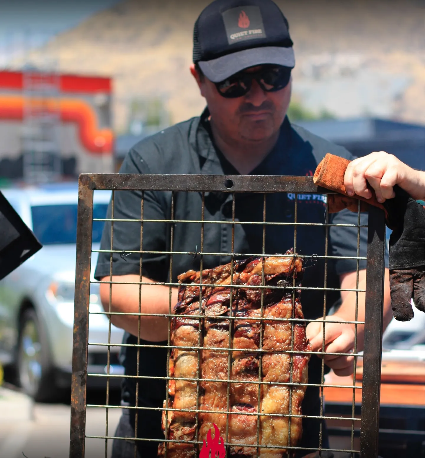 Parrillero mostrando la jaula con el costillar del asado al palo